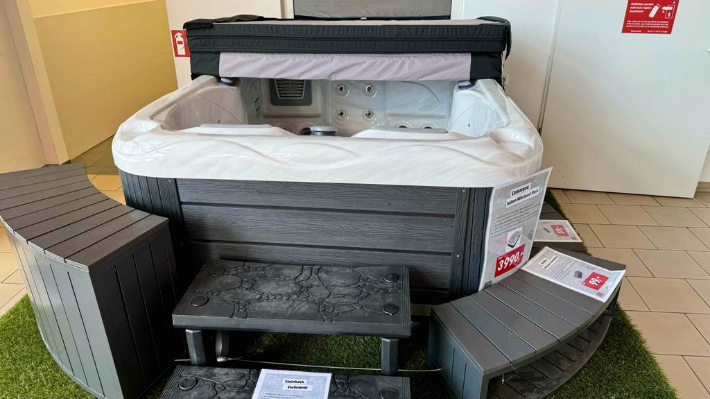 Im Test: Frontansicht einer Whirlpool-Badewanne, vor der ein paar Sitzhocker stehen.