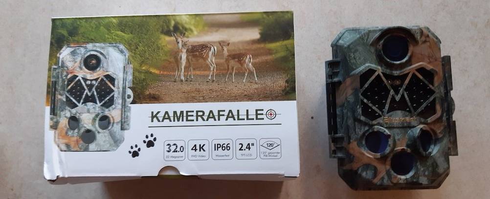Wildkamera neben der Verpackung mit der Bezeichnung Kamerafalle.