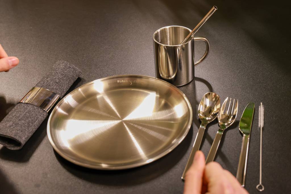 Camping-besteck-Set-Test: Edelstahl-Besteck liegt neben Camping-Geschirr.