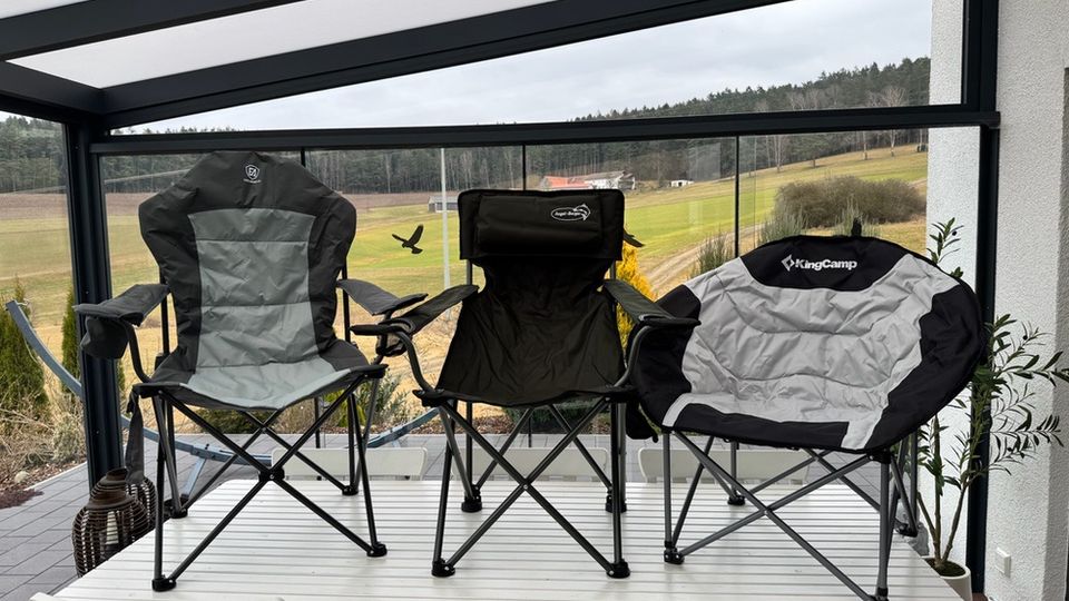 Alle drei Campingstühle stehen nebeneinander auf einem Tisch