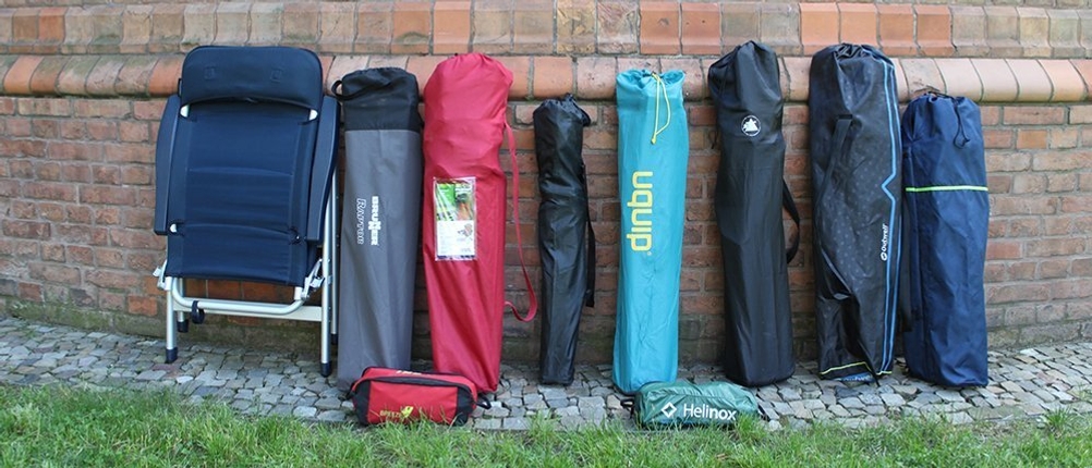 Campingstühle verschiedener Marken in ihren Transporttaschen.