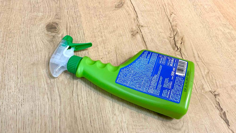 Rückseite einer Flasche getesteten Katzenschrecks auf einem Holzboden liegend.