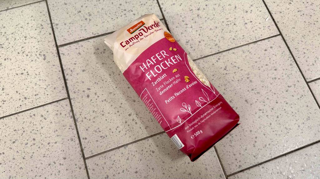 Eine 500-g-Packung mit zarten Haferflocken im Test liegt auf einem Fliesenbelag.