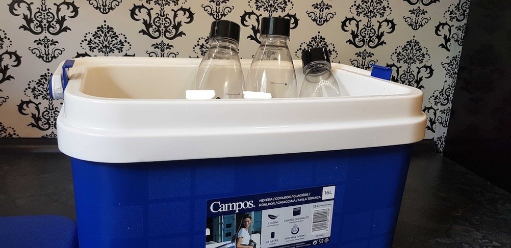 Drei Flaschen aufrecht stehend in einer geöffneten Kühlbox.