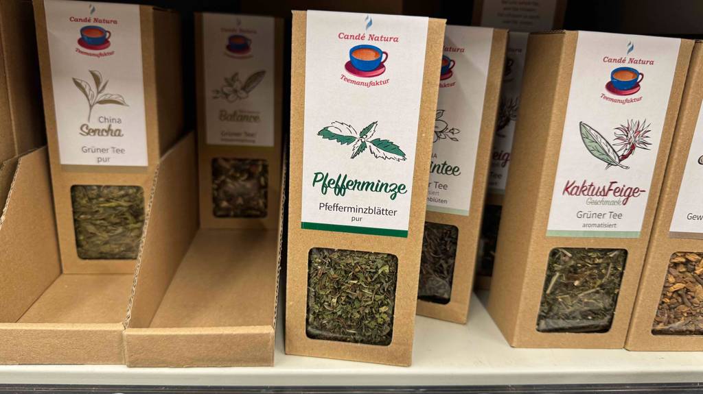 Mehrere Verpackungen mit getrocknetem Pfefferminztee im Test stehen auf einem Verkaufsregal neben weiteren Teesorten.