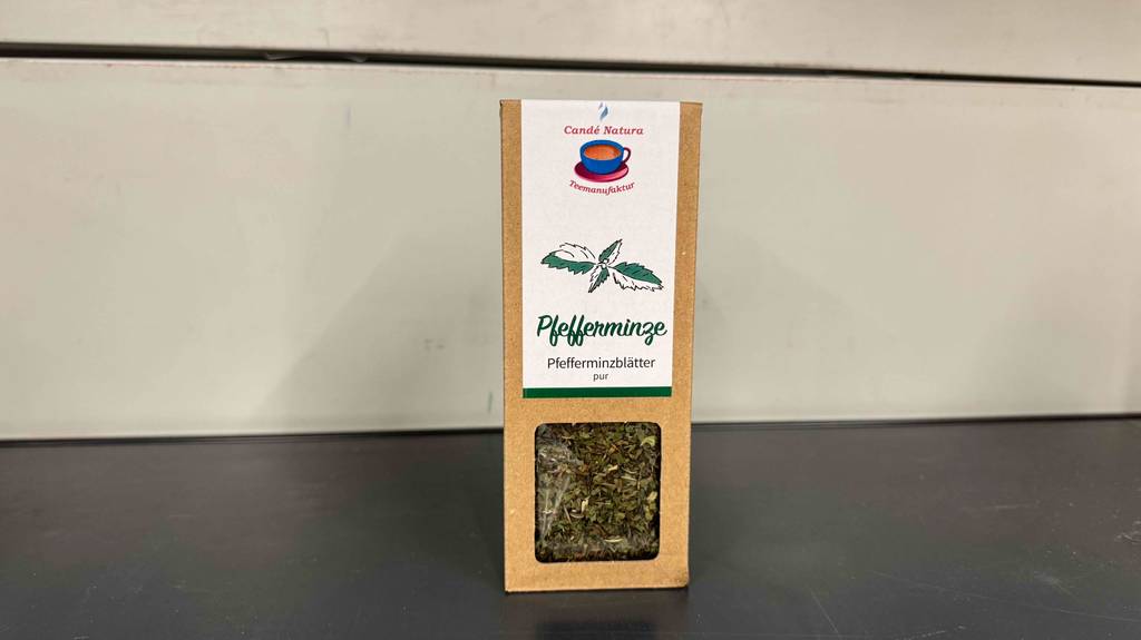 Getestet: Pfefferminztee in einer Pappschachtel inklusive Sichtfenster steht vor einer weißen Wand.