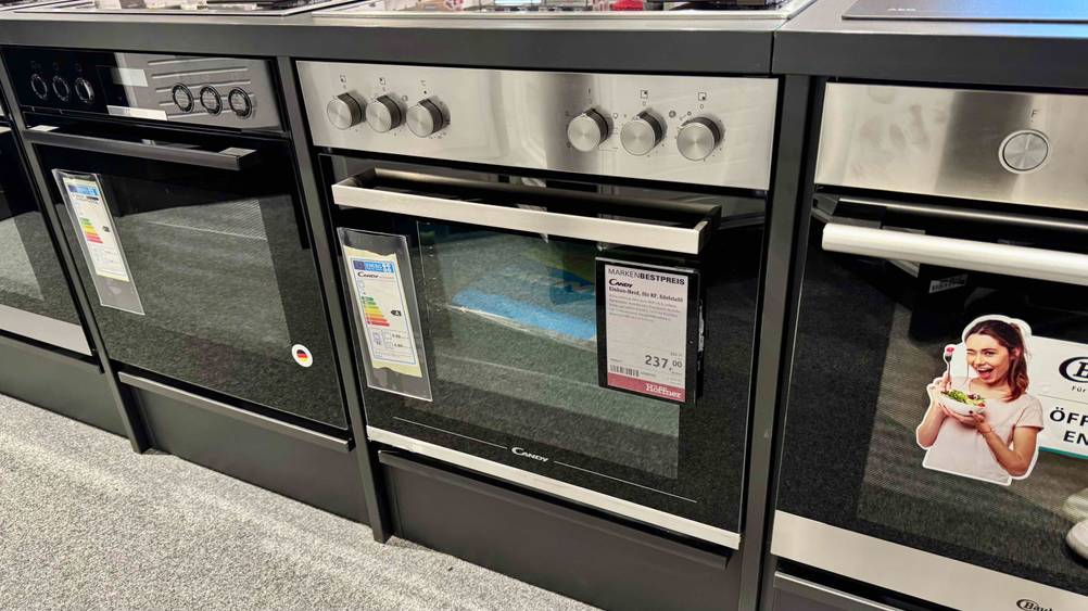Der getestete Candy-Backofen zwischen anderen Geräten in einer Verkaufsausstellung.