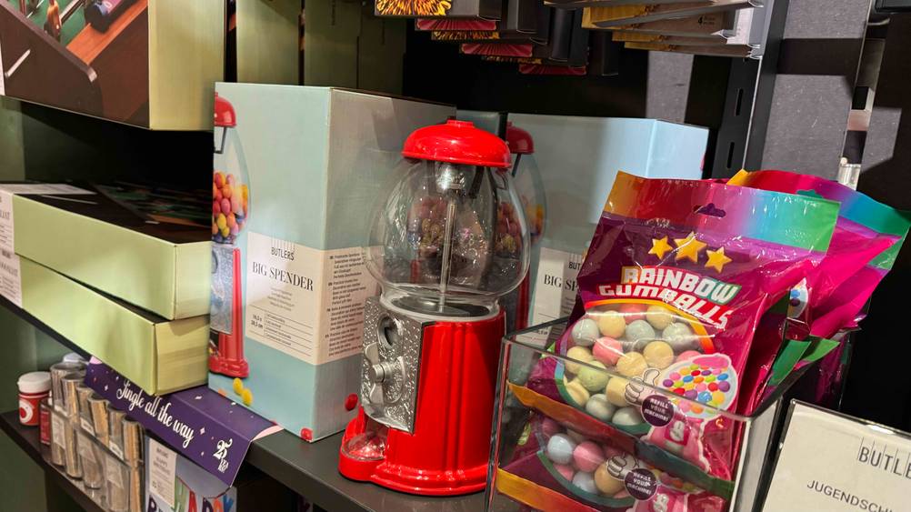 Candy-Grabber getestet: Ein Gerät von schräg seitlich in einem Verkaufsregal neben anderen Produkten.