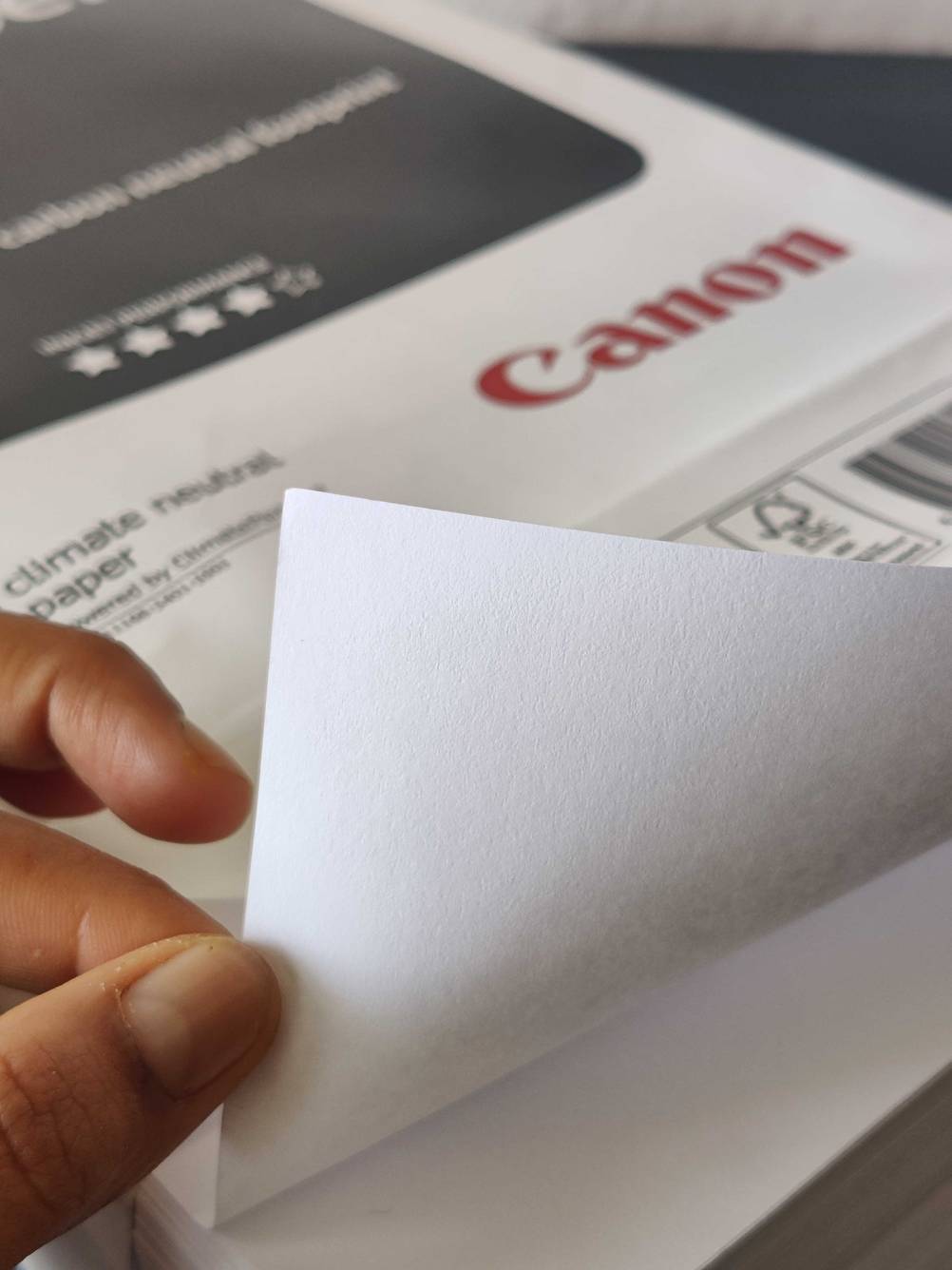 Nahaufnahme eines einzelnen Blattes des getesteten Druckerpapiers von einer Hand gehalten.