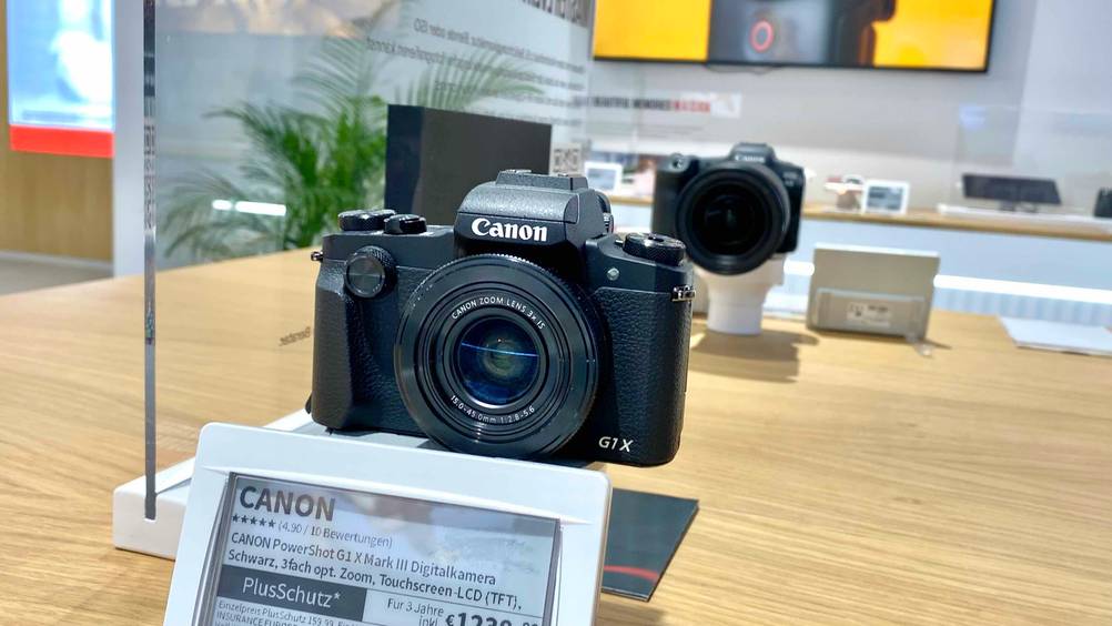 Eine getestete Canon-Digitalkamera in einer Verkaufsaustellung mit Preisschild davor.