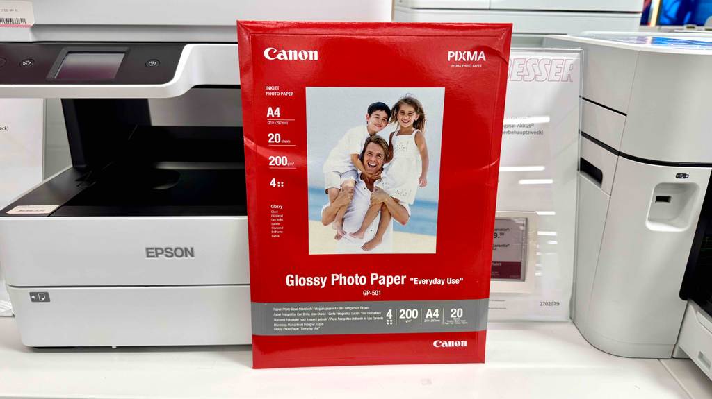 Eine Packung Fotopapier A4 seht zum testen vor einem Drucker.