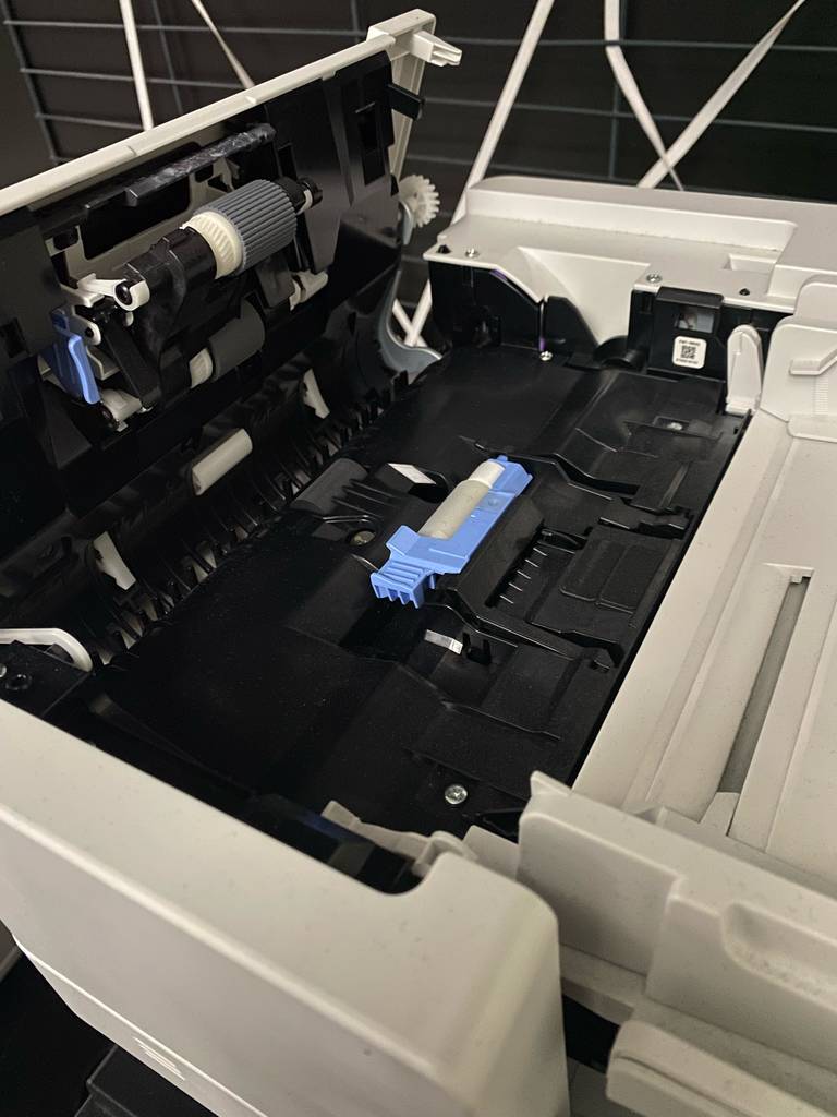 Im Test: ein WLAN-Laserdrucker, mit geöffnetem Deckel, mit Fokus auf die Papiereinfuhr-Vorrichtung.