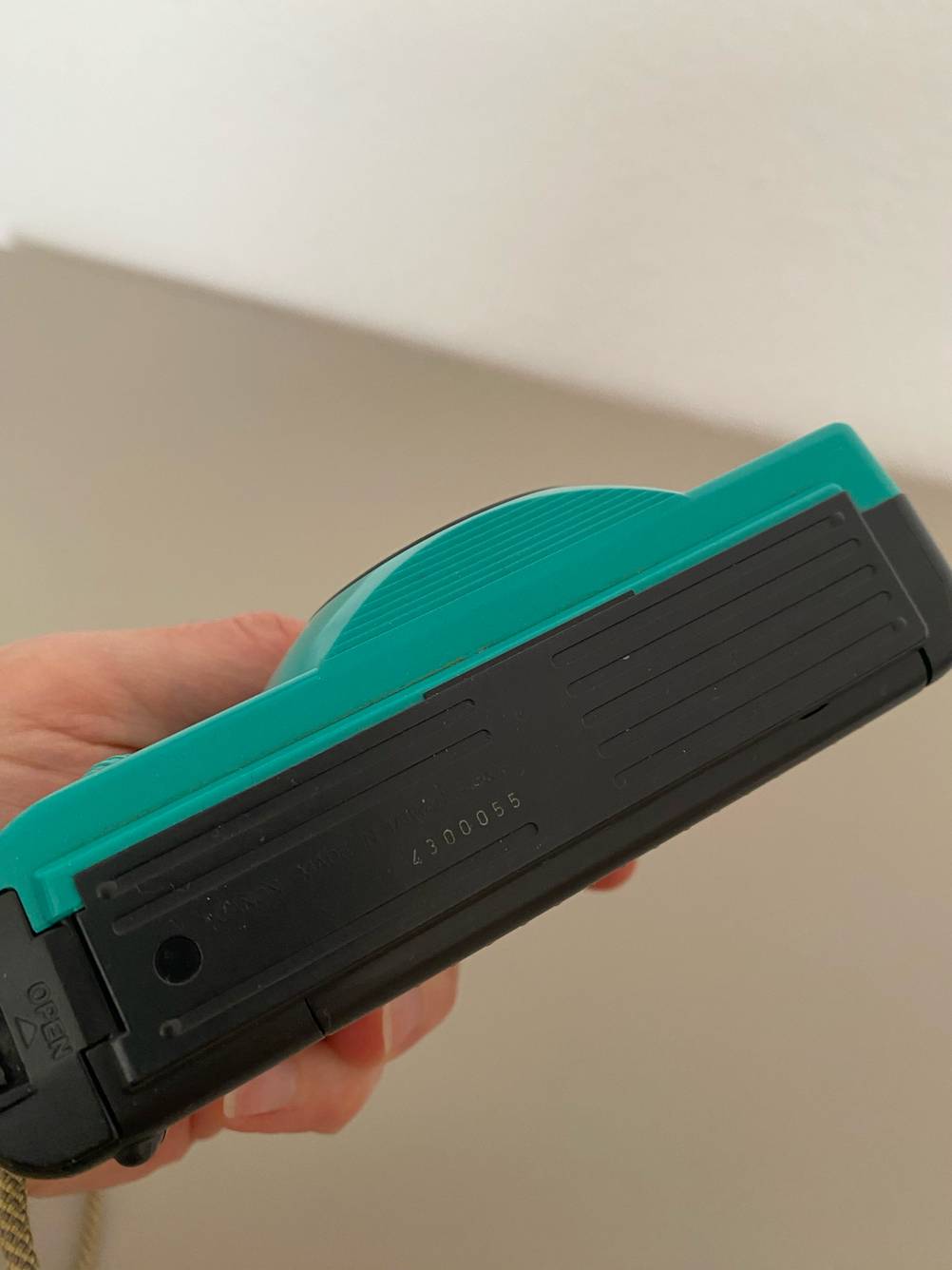 Unterseite einer getesteten Canon-Kompaktkamera von einer Hand gehalten.