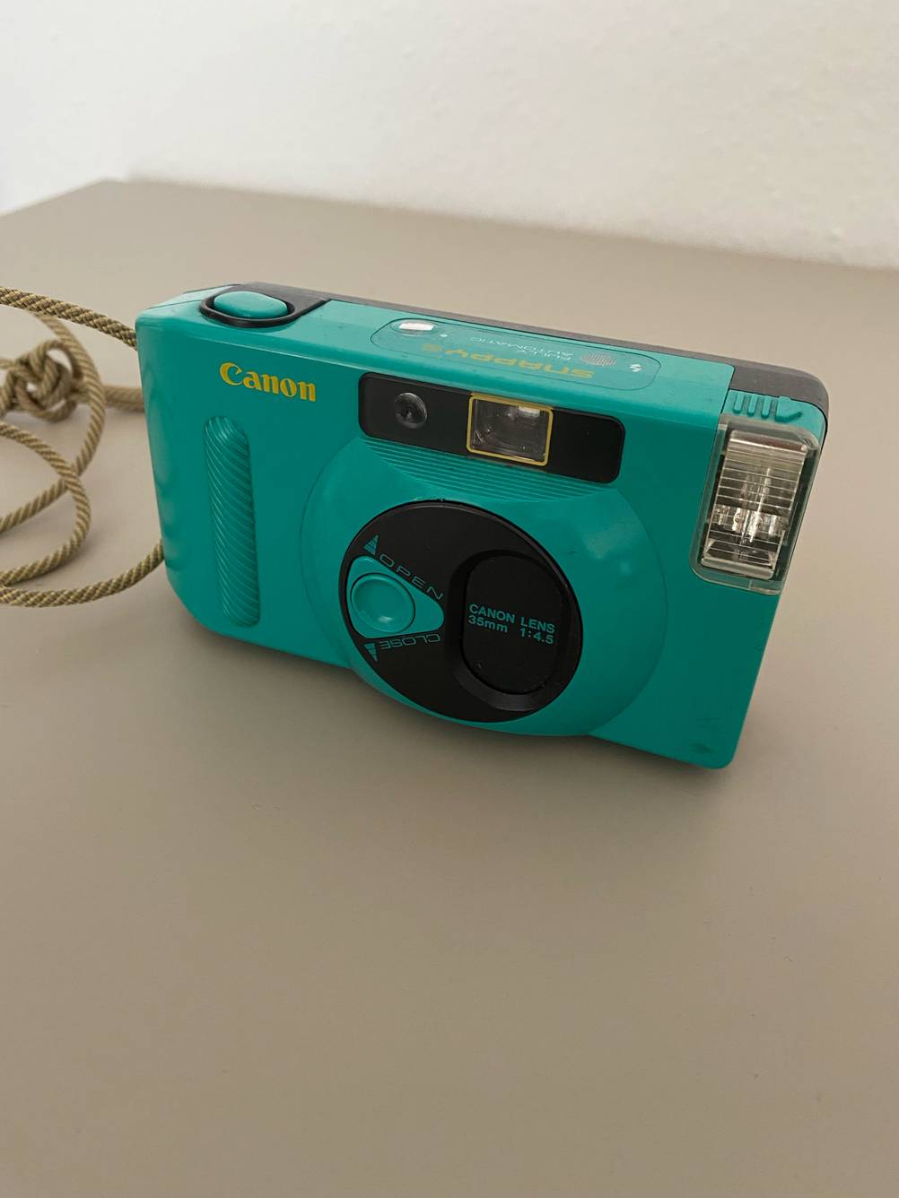 Getestet: Eine Canon-Kompaktkamera von vorne auf einer hellen Fläche.
