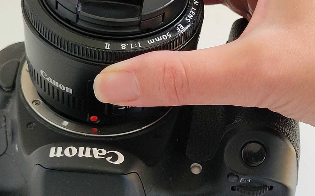 Eine Hand bringt das getestete Canon-Objektiv an einer Kamera an.