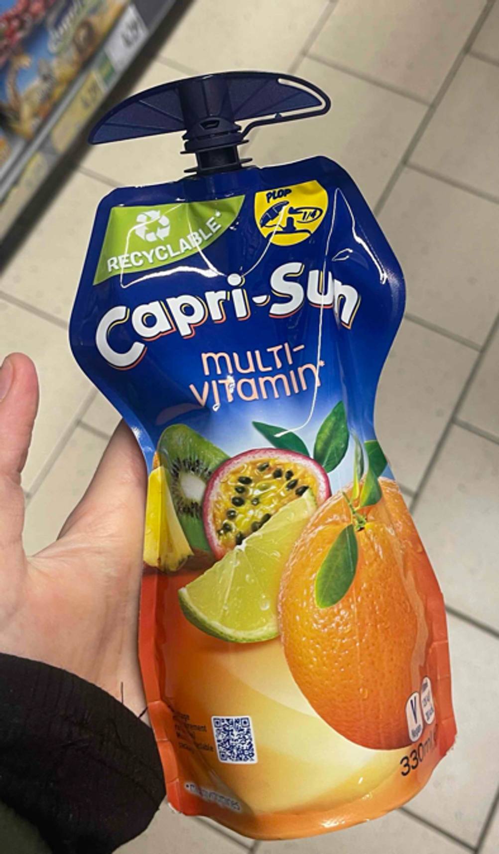 Eine Hand hält die getestete Capri-Sun hoch.