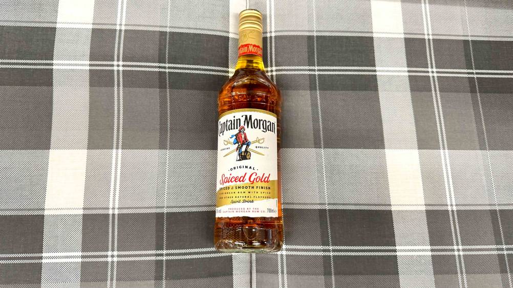 Auf einem karierten Polster liegt eine Flasche Captain Morgan im Test.