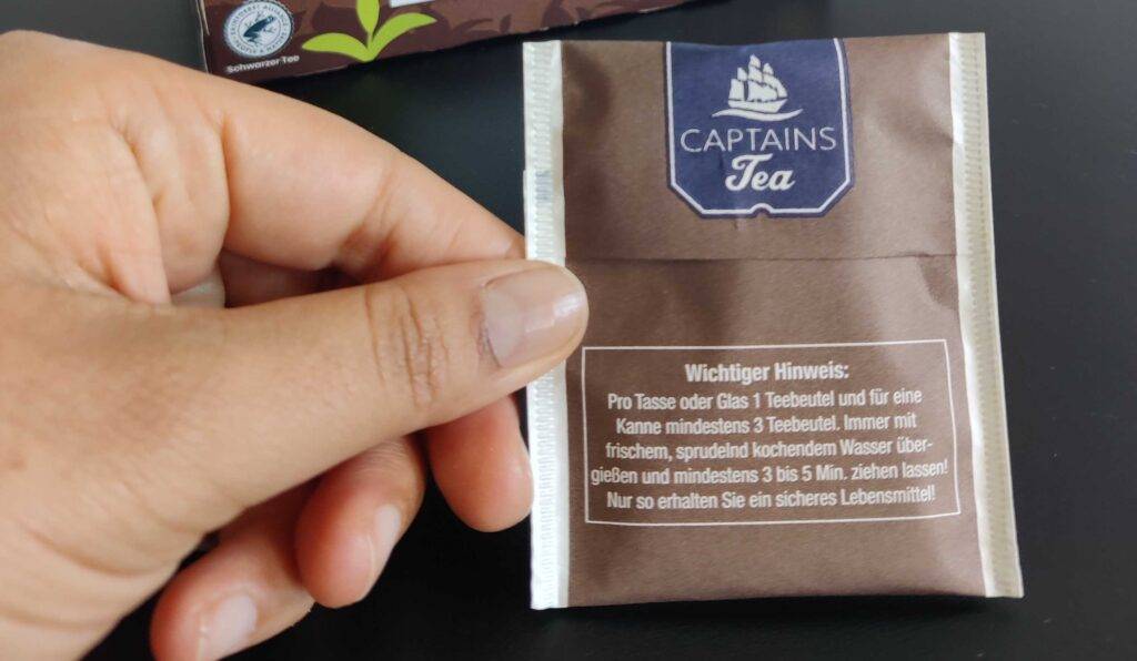 Darjeeling-Tees im Test: Zwei Finger halten einen verpackten Teebeutel.