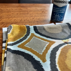 Ein Kissenbezug mit einigen Flecken liegt vor dem Caramba 640112 Polsterreiniger