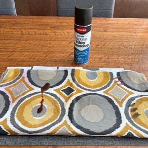 Ein Kissenbezug mit vielen Flecken liegt vor dem Caramba 640112 Polsterreiniger.