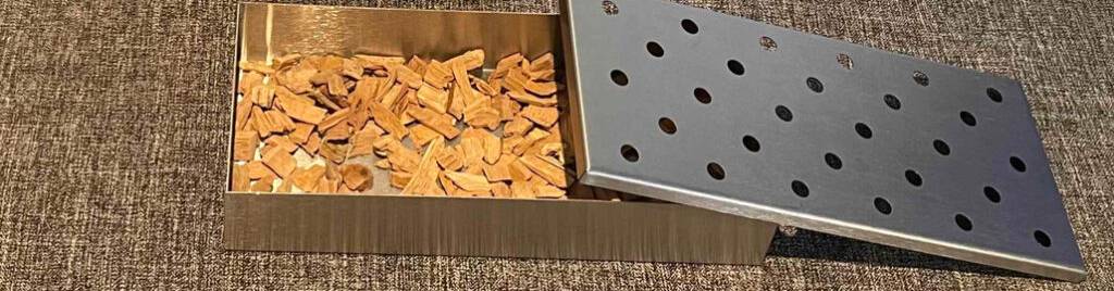 Einzelne getestete Räucherchips liegen in einem Behälter aus Edelstahl.