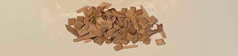 Einzelne Räucherchips im Test liegen auf einem weißen Untergrund.