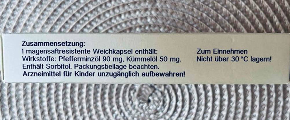Verdauungsenzyme im Test: Nahaufnahme einer weißen Carmentin-Verpackung, mit Fokus auf die seitlichen Produktinformationen.