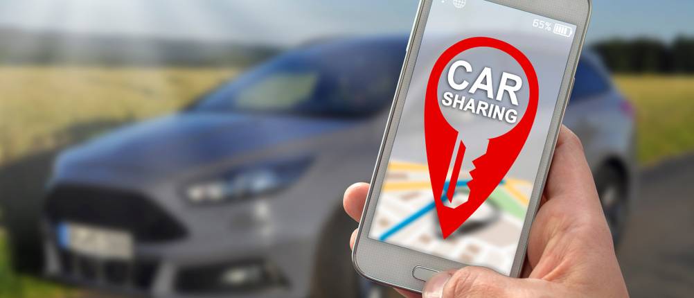 Carsharing-Test: Eine Person hält ein Smartphone mit geöffneter Carsharing-App.