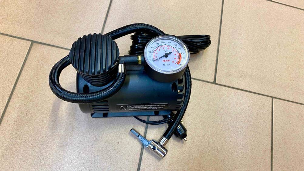 12V-Kompressor getestet: Ein Gerät von oben auf einem Fließenboden.