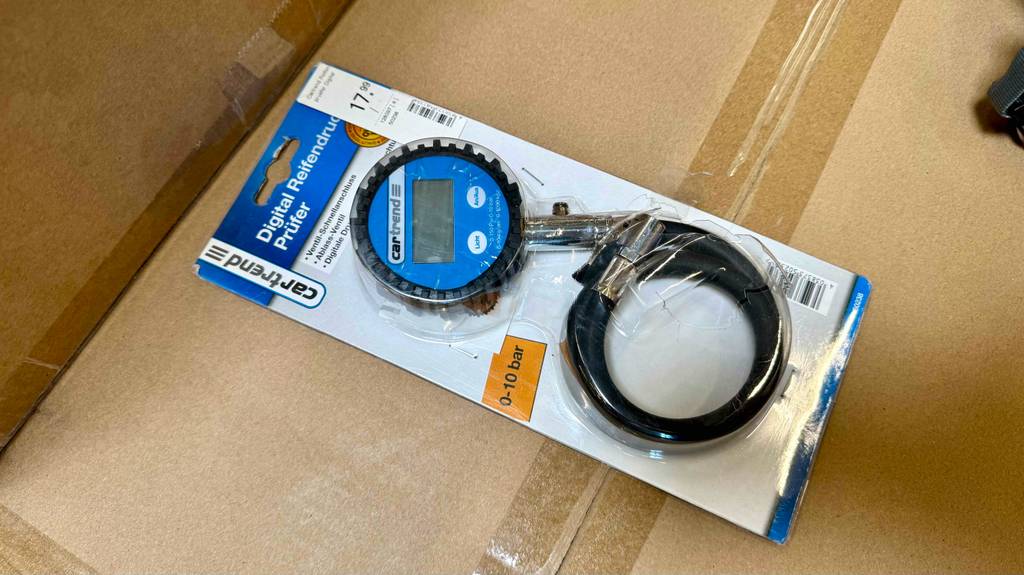 Im Test: Detailansicht eines Reifendruckprüfers digital durch die transparente Blisterverpackung.