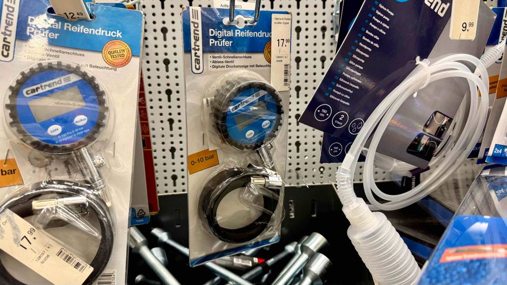 Reifendruckprüfer digital im Test: Mehrere Geräte hängen in einem Regal zwischen anderen Produkten.