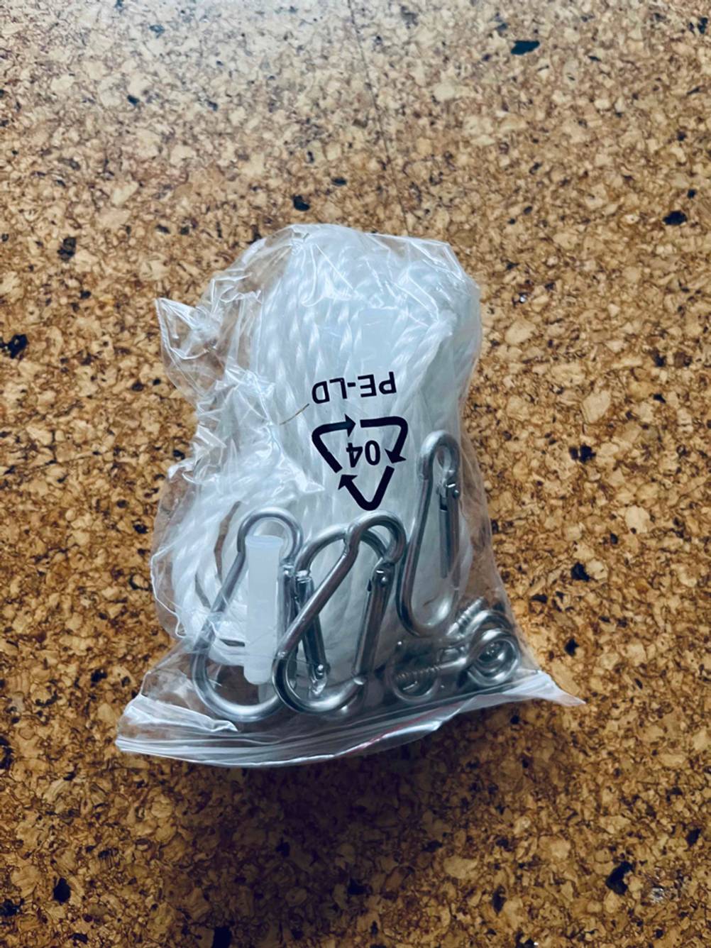 Sonnensegel im Test: eine Packung Karabiner liegt auf einem Korkboden.