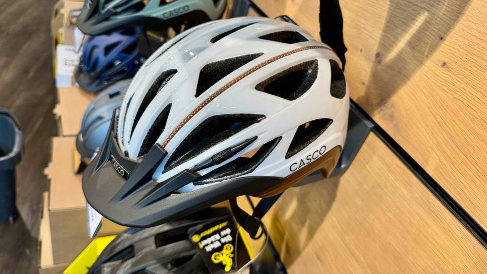 Seitenansicht des Casco-Fahrradhelm im Test an einer Holzwand hängend.