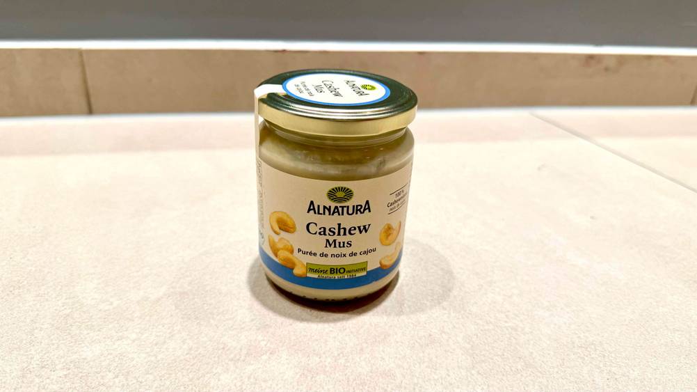 Cashewmus getestet: Ein Glas von schräg oben auf einer hellen Fläche.
