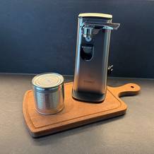 Der Caso-D10-Multiöffner steht neben einer Dose auf einem Holzbrett