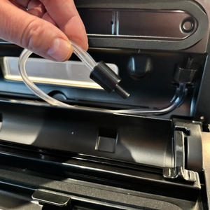 Zwei Finger halten einen Schlauch beim Caso FastVac 500