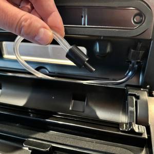 Zwei Finger halten einen Schlauch beim Caso FastVac 500
