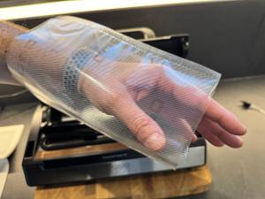 Tüte mit zwei Öffnungen (und Hand dadurch) des Caso FastVac 500