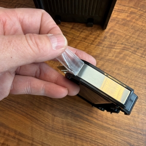 Eine Hand zieht eine Folie von einem Teil des Caso HW 770 Advanced.