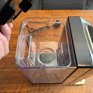 Eine Hand hebt eine Abdeckung vom Wassertank des Caso HW 770 Advanced.