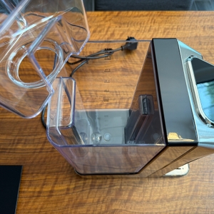 Eine Hand hebt den Halter für den Filter aus dem Wassertank vom Caso HW 770 Advanced.