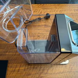 Eine Hand hebt den Halter für den Filter aus dem Wassertank vom Caso HW 770 Advanced.