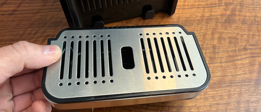 Eine Hand hebt die Abtropfschale vom Caso HW 770 Advanced hoch.