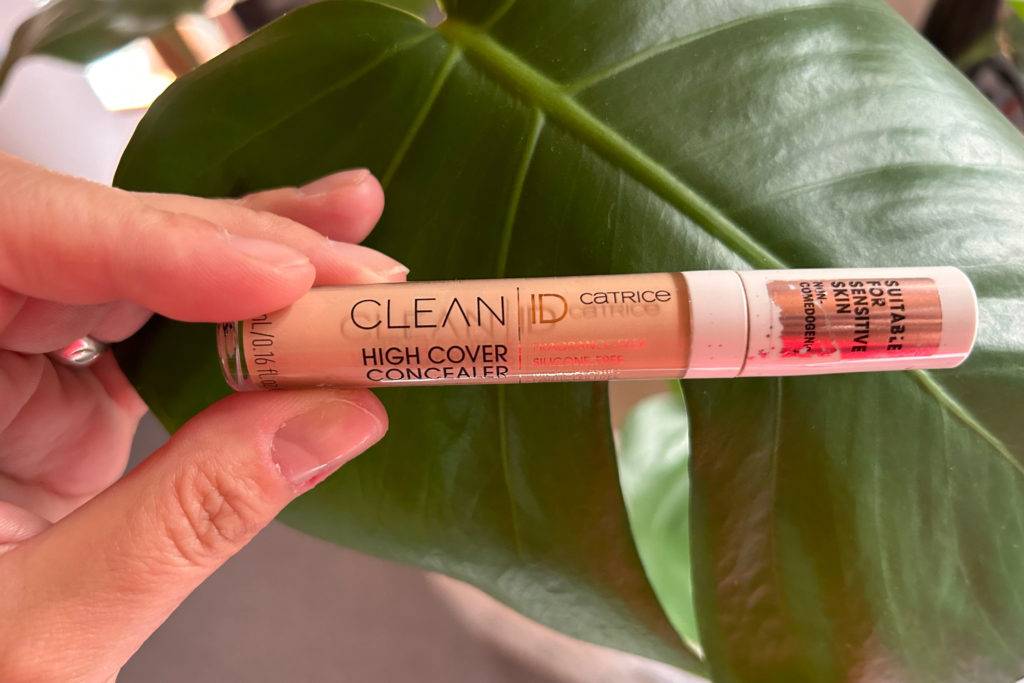 Catrice Clean High Cover Concealer in der Hand vor einer Pflanze