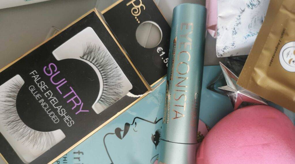 Getestete wasserfeste Mascara liegt neben selbstklebenden Wimpern in einem häuslichen Schminkbereich.
