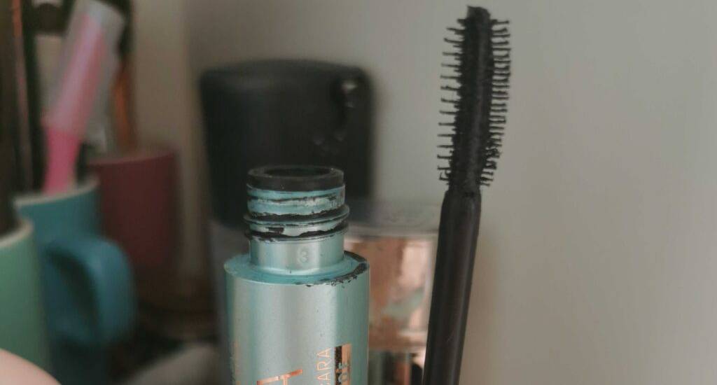 Getestete wasserfeste Mascara steht geöffnet in einem häuslichen Schminkbereich.