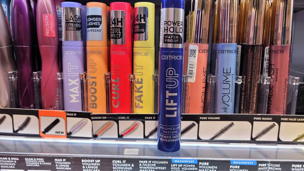 Catrice-Mascara im Test: eine blaue Mascara steht vor einem Regal mit vielen anderen.