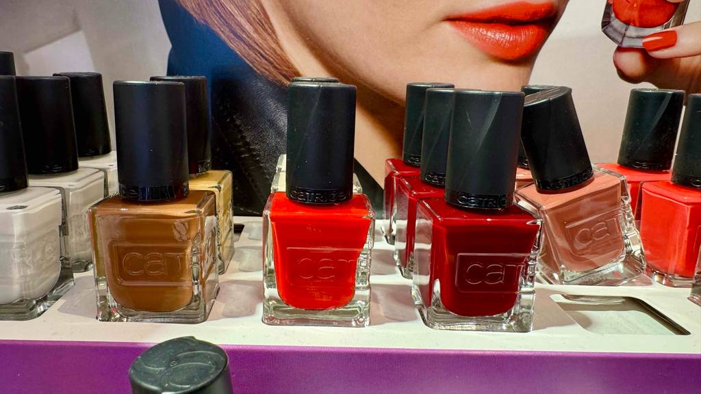 Roter Nagellack im Test steht neben andersfarbigen Nagellacken auf einem Verkaufsregal.