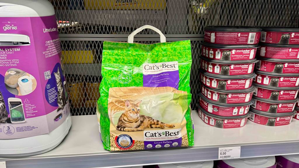 Eine Packung Katzenstreu-Pellets steht zum testen in einem Regal zwischen Katzentoiletten.