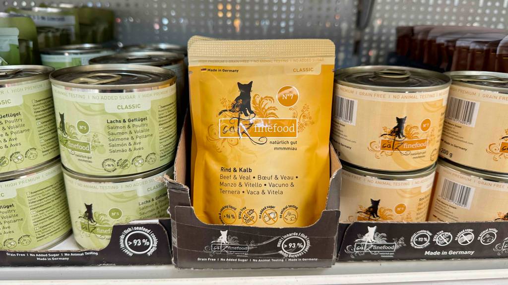 In einem Verkaufsregal steht neben weiterem Katzenfutter das getestete Katzenfutter ohne Zucker und Getreide in einem wiederverschließbaren 85-g-Beutel.